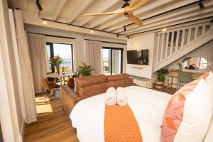 ein Schlafzimmer mit einem Bett mit zwei weißen Schuhen darauf in der Unterkunft Oceanfront Duplex Apartments, Hermanus Waterfront in Hermanus