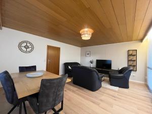 ein Wohnzimmer mit Holzdecke und einem Tisch und Stühlen in der Unterkunft Terrassenwohnung in ruhiger Lage -3 Zimmer A96 nähe in Schönwag