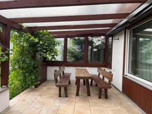 ein Holztisch und Bänke auf einer Terrasse in der Unterkunft Terrassenwohnung in ruhiger Lage -3 Zimmer A96 nähe in Schönwag