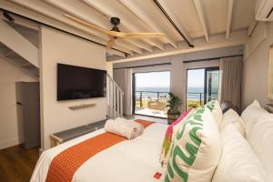 a bedroom with a bed and a large window at Oceanfront Duplex Apartments, Hermanus Waterfront in Hermanus
