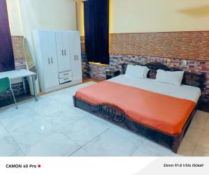 Un dormitorio con una cama y una pared de ladrillo. en Kimkeri Hotel, en Ogbojo