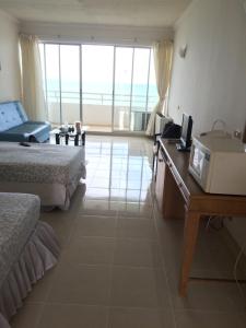 um quarto de hotel com 2 camas e uma secretária com um micro-ondas em Milford Paradise Condominium em Pran Buri