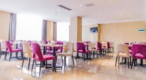 ein Esszimmer mit Tischen, Stühlen und lila Stühlen in der Unterkunft Lavande Hotels Xuzhou Yunlong Wanda Medical University in Xuzhou