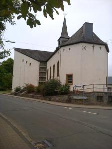 a white church with a steeple on the side of a street at Ferienwohnung Irmgard in Plein