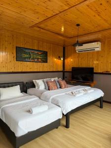 Giường trong phòng chung tại บ้านสี่เหลี่ยม รัชนากร โฮมสเตย์