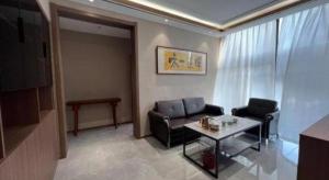 a living room with a couch and a table at City 118 Hotel Aodele in Songguantun