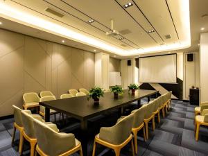 ein Konferenzraum mit Tisch und Stühlen und einer Leinwand in der Unterkunft Xana Hotelle Shenyang Zhongshan Plaza the Affiliated First Hospital of China Medical University in Shenyang