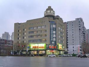 ein großes Gebäude mit einem Schild darauf in der Unterkunft James Joyce Coffetel Shenyang North Railway Station Qishan Road Metro Station in Shenyang