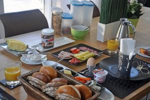 einen Tisch mit Teller mit Speisen und Orangensaft in der Unterkunft Frankfurt Bed & Breakfast in Frankfurt am Main