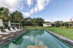 an image of a swimming pool in a backyard with chaise lounge chairs at Casa Bali Costa Brava in Llofríu