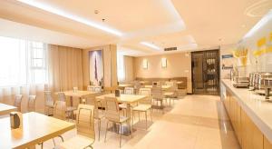 un restaurant avec des tables et des chaises dans une salle dans l'établissement City Comfort Inn Nanning Jinhu Plaza Langxi Metro Station Exhibition, à Nanning