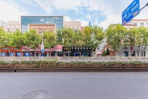 eine Straße in einer Stadt mit Gebäuden und Bäumen in der Unterkunft GreenTree Inn Yancheng Dongtai West Wanghai Road Shell Hotel in Dongtai