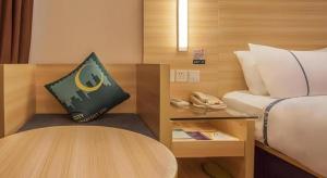 Cette chambre comprend un lit, une table et un téléphone. dans l'établissement City Comfort Inn Nanning Jinhu Plaza Langxi Metro Station Exhibition, à Nanning 142 autres photos