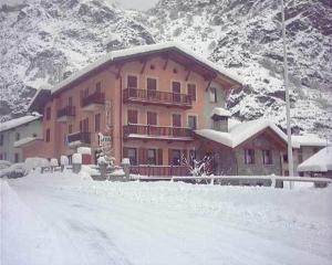 a large building in the snow with a mountain at Hotel Beau Sejour in Arvier