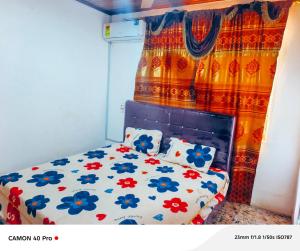 1 dormitorio con cama con cortina de flores en Kimkeri Hotel, en Ogbojo 9 fotos más
