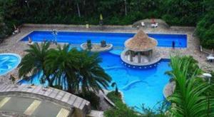 ein großer blauer Pool mit Palmen um ihn herum in der Unterkunft Nan Guo Hotel in Guangzhou