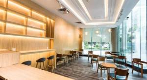 ein Restaurant mit Holztischen und -stühlen und Fenstern in der Unterkunft Nan Guo Hotel in Guangzhou