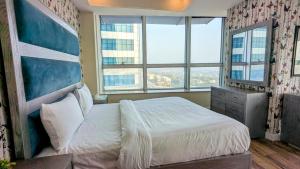 a bedroom with a large bed with a large window at Centaurus mall two bed apartment in Islamabad