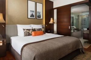 a hotel room with a large bed and a bathroom at Anantara Riverside Bangkok Resort in Bangkok