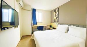 une chambre d'hôtel avec un lit blanc et un bureau dans l'établissement 7 Days Inn Guangzhou Huangpu East Zone Times Plaza, à Canton 115 autres photos