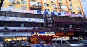 une scène de rue avec des voitures garées devant un bâtiment dans l'établissement 7 Days Inn Guangzhou Huangpu East Zone Times Plaza, à Canton
