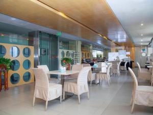 une salle à manger avec des tables et des chaises dans un restaurant dans l'établissement Jinjiang Inn Zhenjiang Jiangsu University Suning Plaza, à Zhenjiang