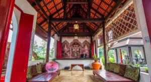 ein Raum mit Bänken und einem Tisch in einem Gebäude in der Unterkunft Gudi Boutique Resort in Mae Rim