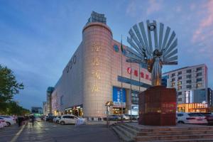 a building with a statue in front of it at 7 Days Premium Zibo Jinjing Avenue the Mixc in Zibo