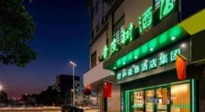 ein Gebäude mit grünen Schildern an der Seite in der Unterkunft Vatica Yangzhou Dongguan Street Hotel in Yangzhou