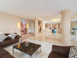 un salon avec un canapé et une table dans l'établissement Vienna 3 Best Hotel Shenzhen Shazui Road Branch, à Shenzhen