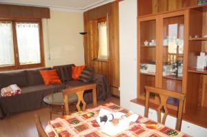 uma sala de estar com um sofá, uma mesa e cadeiras em Manad cod CIR n 0329 em Aosta