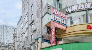 un groupe de grands bâtiments avec des panneaux. dans l'établissement Pai Hotel Guiyang Daximen West Zhongshan Metro Station, à Guiyang