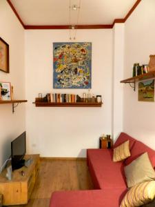 ナポリにあるModern Flat Cavourの赤いソファ付きのリビングルーム、壁に絵画
