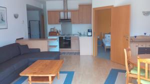 ein Wohnzimmer mit einem Sofa und einem Tisch sowie eine Küche in der Unterkunft Haus Astrid in Keutschach am See
