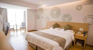 a hotel room with a large bed and a desk at GreenTree Inn Suqian Suyu District Red Star Macalline in Zhuoxu +77 photos