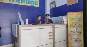 deux hommes se tiennent à un comptoir dans un magasin dans l'établissement Hotel Syariah Tremigo Guesthouse, à Tangkil