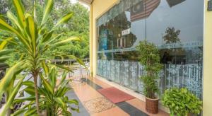 a balcony with plants and a large window at Sz Hotel in Kampong Tebing Rabak