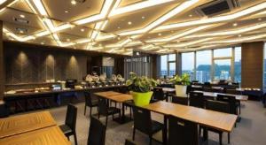 ein Restaurant mit Holztischen und -stühlen und Fenstern in der Unterkunft Hotel Gran Cerezo Kagoshima in Kagoshima