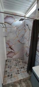 Un baño con pared de mármol con ducha. en JL Valley Suites, en Ciudad de Cauayán