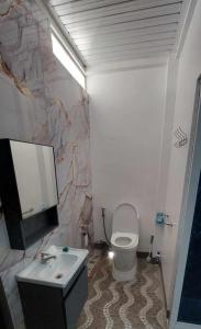 Un baño con un inodoro blanco y un lavabo. en JL Valley Suites, en Ciudad de Cauayán