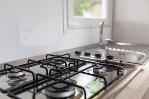 a stove top oven sitting next to a sink at Camping Delfino in Albenga