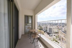 a balcony with a table and chairs and a large window at Dar Dalya in Dāliyat el Karmil