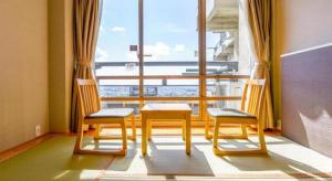 une chambre avec deux chaises et une grande fenêtre dans l'établissement Ooedo Onsen Monogatari Minoh Kanko Hotel, à Minoh