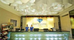 deux personnes debout au comptoir d'un magasin Saphir dans l'établissement Guilin Sapphire hotel, à Guilin