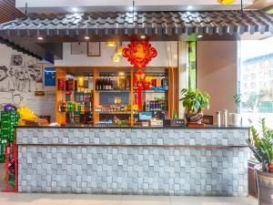 un bar dans un restaurant avec un comptoir dans l'établissement GreenTree Alliance Sanya Jiyang District Yalongwan Road Hotel, à Da'ancun