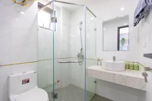 une salle de bains avec douche, toilettes et lavabo dans l'établissement Hera West Lake Apartment, à Hanoï 77 autres photos