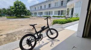 un vélo garé devant un bâtiment dans l'établissement KS Quảng Trường Mỹ Tho, à Ấp Mỹ Hòa
