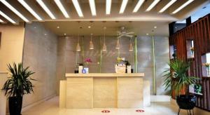 un hall d'entrée avec un comptoir avec des plantes en pot et des suspensions dans l'établissement Aura One Hotel, à Baguio