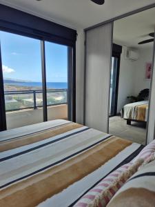 une chambre avec un grand lit avec vue sur l'océan dans l'établissement Appartements sur le littoral TROIS BASSINS, à Trois Bassins