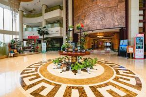 eine Lobby mit einem Tisch mit Topfpflanzen darin in der Unterkunft Nanchang Oriscene Garden Hotel in Nanchang + 283 Fotos